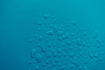 splashes of water drops on a blue background. A round drop of water. Drops, splashes, splashes, abstract figures from the water.
