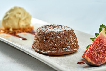 Dessert chocolate fondant with ice cream in a white plate on a white plate