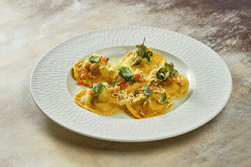 Ravioli with different fillings in sauce and parmesan in a white plate