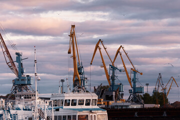 Fototapeta premium Port cranes in the harbor at sunset. River port in Kazan, Russia. Port dock.