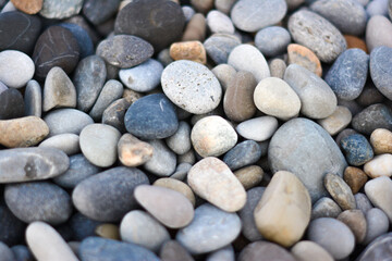 Fototapeta na wymiar Abstract background with round pebble stones different colors. Stones beach smooth. Top view. Soft focus.