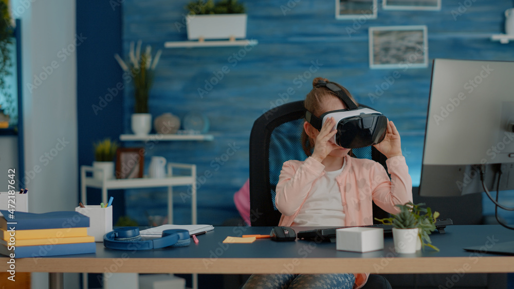 Poster schoolgirl using vr glasses for homework and learning at desk. young child with headset for virtual 
