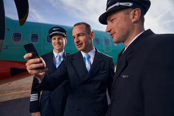 Three pilots taking a picture of themselves on smartphone