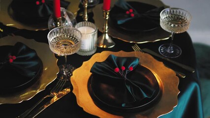 Christmas or Thanksgiving celebration. Close up of pre paired decorated Christmas table with beautiful dishes: plates, wineglasses, candles, napkins. 