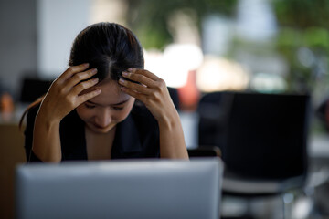 Stressed business woman working on laptop, tired and overwhelmed, headaches and stress, Cause of...