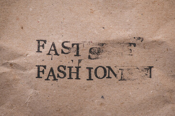 Gestempelter Text auf zerknittertem Papier. Fast Fashion.