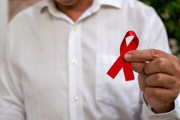 man holding red ribbon. AIDS prevention campaign. December red. blood donation