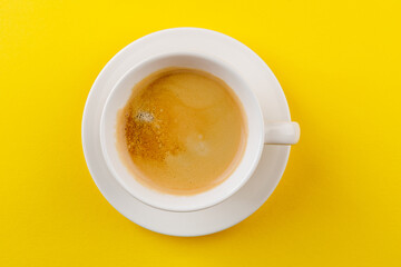 Black coffee in a cup on a yellow background