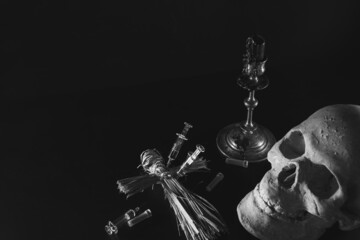 Voodoo doll and candles. Skull and syringes on a black background. People management concept....
