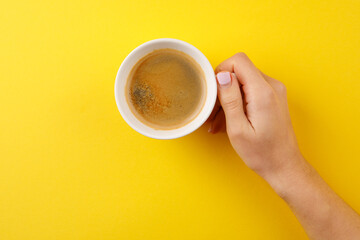 Black coffee in a cup on a yellow background