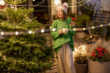 Woman with cookie and cup at New Year's decorated backyard
