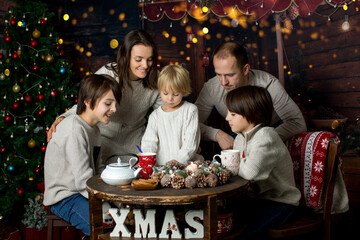 Obraz na płótnie Canvas Happy family with children and pet dog, enjoying Christmas time together, celebrating