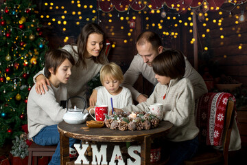 Happy family with children and pet dog, enjoying Christmas time together, celebrating