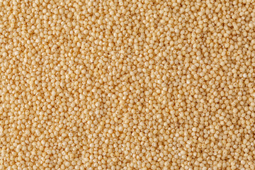 Macro photo couscous. Yellow grains of wheat grits, cuscus, semolina, universal porridge for breakfast.Background texture of couscous grains. Top view.