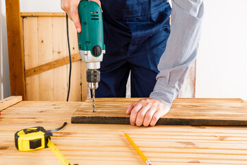 Handyman in blue uniform works with electricity automatic screwdriver. House renovation conception.