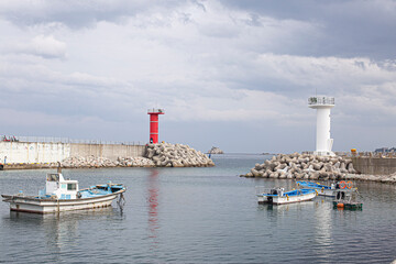 Naklejka premium White and red lighthouses on seaside breakwater. South Korea.