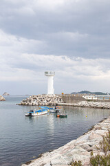 Fototapeta na wymiar view of a lighthouse on breakwater against sea horizon.