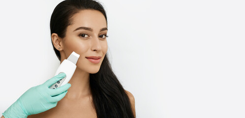Beautiful woman while ultrasonic peel skin procedure. Facial skin care, cleansing facial skin,...