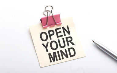 OPEN YOUR MIND text on the sticker with pen on the white background