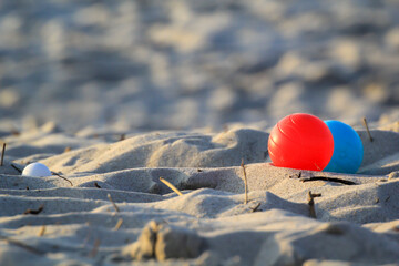 Farbige Boulekugeln liegen am Strand. Spielszene beim Boule.
