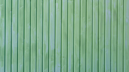 Eine grüne Metallwand mit senkrechte Linien als Hintergrund