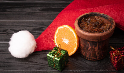 hookah bowl with tobacco with a Christmas red hat on a dark background. Christmas accessories