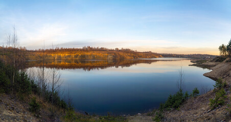 Naklejka na ściany i meble The windless surface of the lake and the reflection of clouds on calm water. Leningrad region, Vsevolozhsk