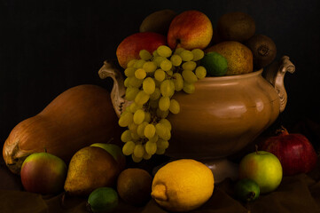 Still life with fruits in the Spanish style on a dark background.