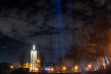 Symbolic light rays and candles near the Memorial to Holodomor victims during a commemoration ceremony in Kyiv, Ukraine