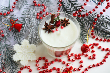 christmas gift concept. Christmas candle made from natural soy wax and spruce branches with garlands 