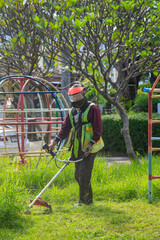 An old Asian gardener's man post with lawnmowers before working in the garden.