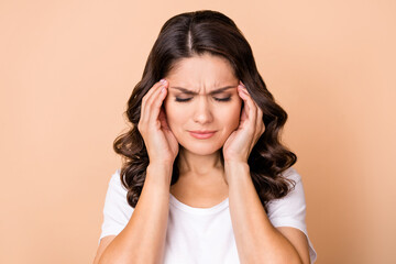 Photo of sad young curly hairdo lady hands head wear white t-shirt isolated on beige color...
