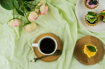 breakfast in the bed. a cup of coffee, mini tortillas with fruit and a bouquet of pink roses. the concept of celebrating Valentine's Day, 8 March.