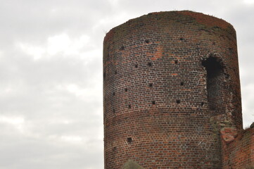 Castle ruins in Koło. Destroyed towers and defensive walls made of red brick on the bank of the...