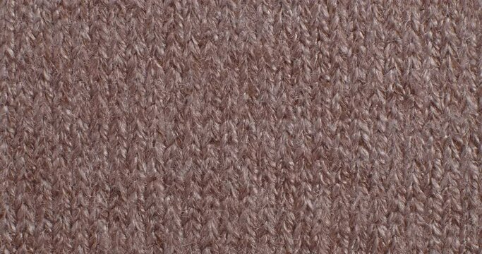 The texture of the knitted part is close-up. Macro fragment. Brown background.