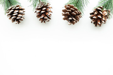 White table with Christmas decoration including pine branches and pine cones. Merry Christmas and...