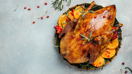 Roast Christmas duck with rosemary and oranges on rustic wooden table. Traditional roasted stuffed Christmas Peking duck