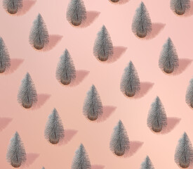 Winter pattern with Christmas tree on a coral background. Creative pastel holiday idea.