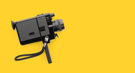 Fototapeta premium Super 8 movie camera isolated on yellow background. Copy space