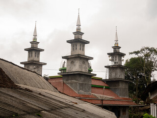 A view of the three distinct minarets of a local mosque, a significant religious and cultural...