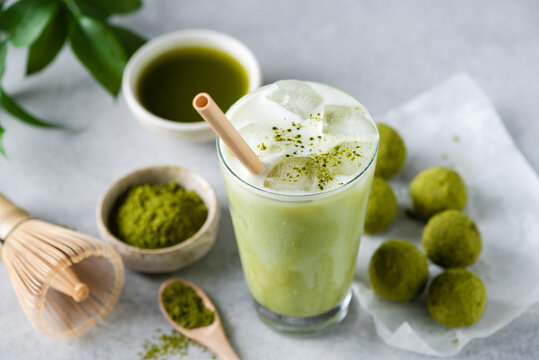 Ice latte Matcha tea in glass served with raw energy balls. Vegan food