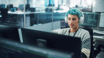 In Diverse Office: Portrait of Stylish Woman in Headphones Working on Desktop Computer. Modern...