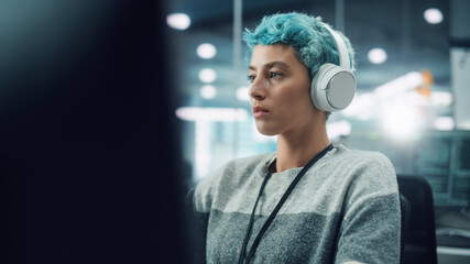 In Diverse Office: Portrait of Young Stylish Woman Working on Desktop Computer. Focused Motivated Girl Creating Modern Content, Colorful Project Design. Uses Headphones to Listen to Podcast, Music