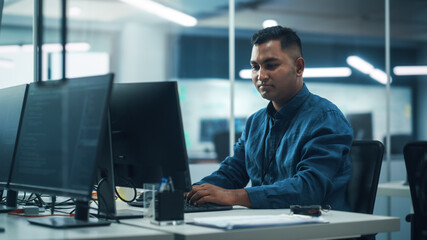 Fototapeta na wymiar In Diverse Office: Portrait of Handsome Indian Man Working on Desktop Computer. Professional Programmer Creates Innovative Software, Modern App Design. Stylish Multi-Ethnic Authentic Workplace
