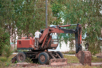 the excavator driver climbs into the cab