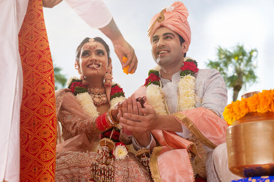 Indian bride and groom performing ritual during wedding ceremony
