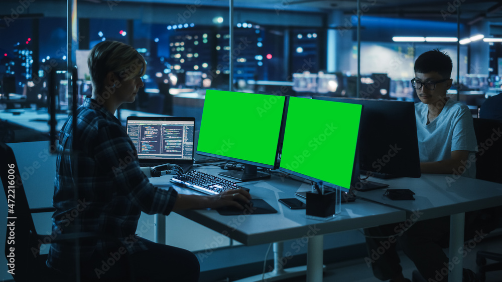 Poster Diverse Teamwork in Office at Night: Person with Disability Using Prosthetic Arm to Work on Green Screen Chroma Key Computer. Team of Software Engineers work Late to create Innovative App