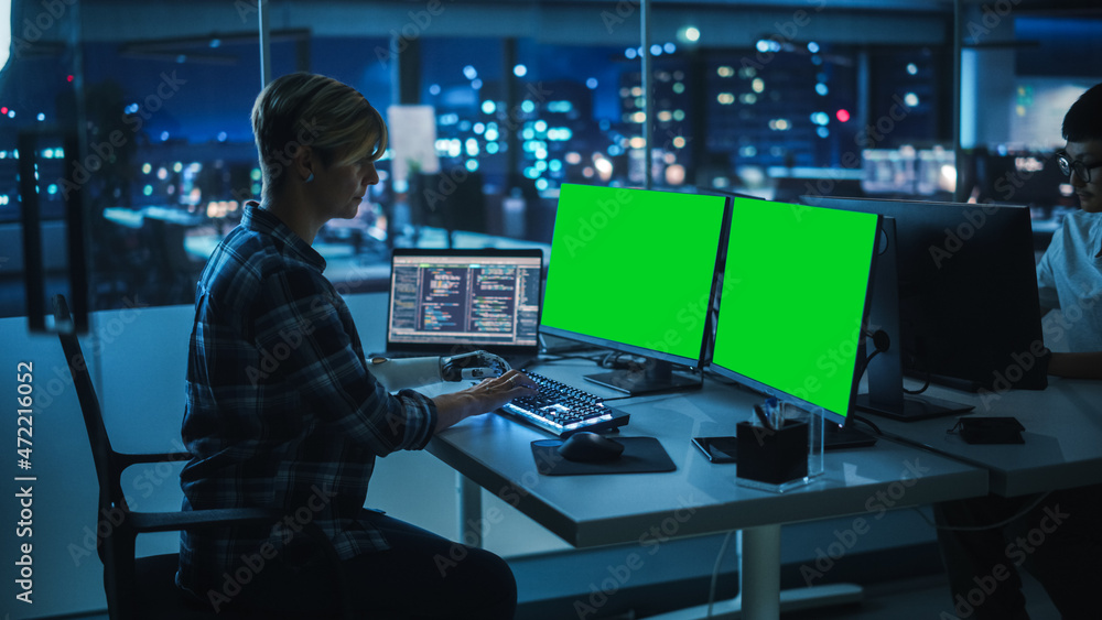 Poster Diverse Teamwork in Office at Night: Person with Disability Using Prosthetic Arm to Work on Green Screen Chroma Key Computer. Team of Software Engineers work Late to create Innovative App