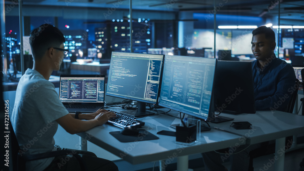 Poster Night Office: Young Japanese Man in Working on Desktop Computer. Diverse Multi-Ethnic Team of Programmers Typing Code, Creating Modern Software, e-Commerce App Design, e-Business Programming.