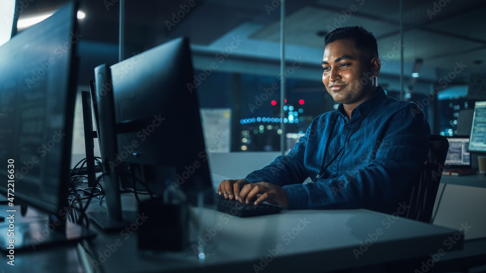 Poster Night Office: Portrait of Handsome Indian Man in Working on Desktop Computer. Digital Entrepreneur Typing, Creating Software, e-Commerce App Design, Programming. Thoughtful Happy Man Finding Solution